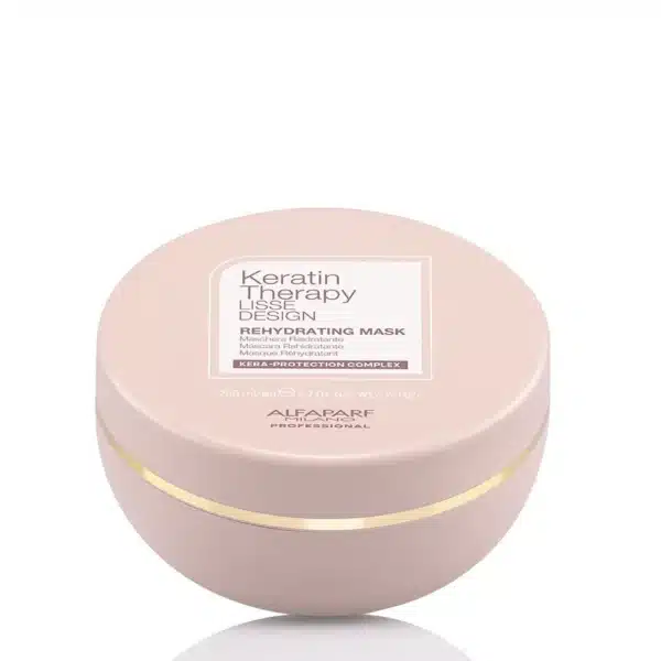 Round pastel pink cosmetic jar labeled Keratin Therapy Rehydrating Mask by Alfaparf Milano, with a gold band around the base.